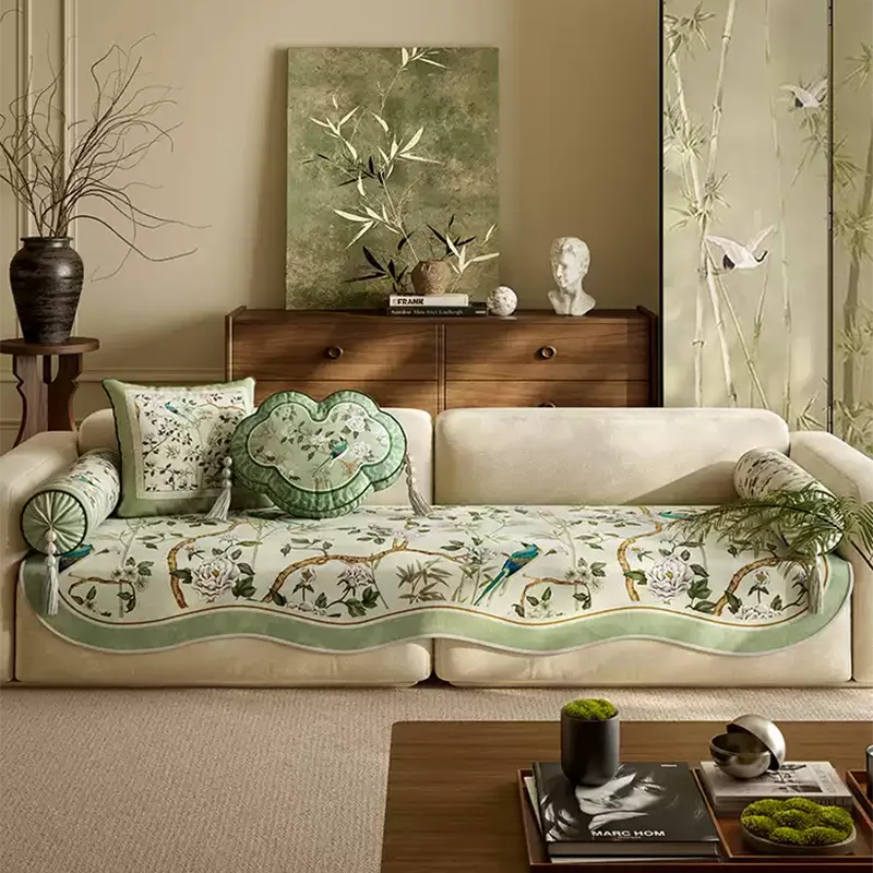 Chinoiserie vintage jade green sofa slipcover on ivory sofa with matching heart-lock, armrest, and square throw pillows.
