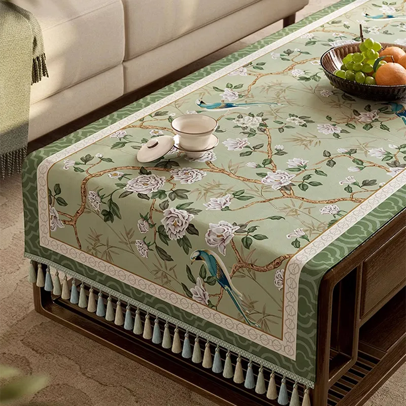 Side view of chinoiserie vintage jade green tablecloth draped over a coffee table.