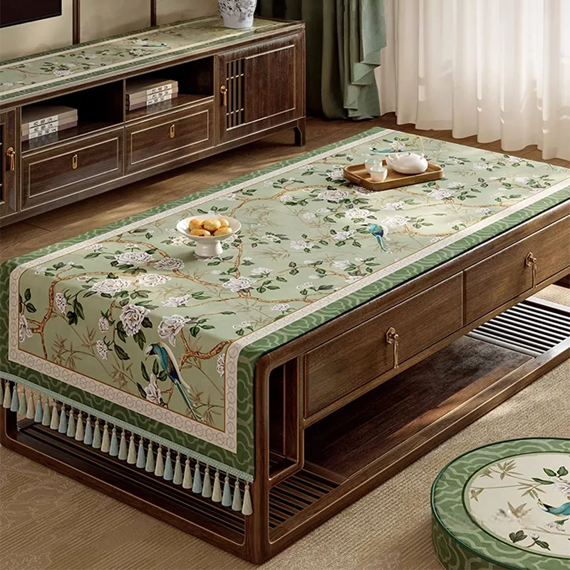 Chinoiserie vintage jade green tablecloth on living room coffee table with tea snacks.