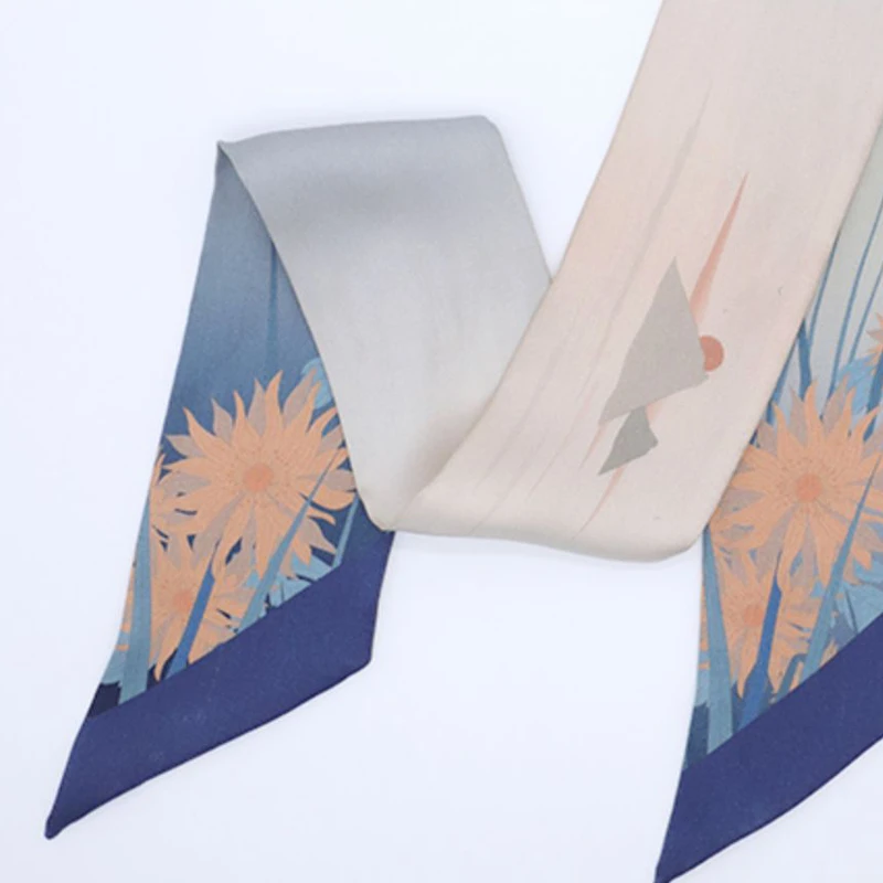 Detail view of the Cloud & Water mulberry silk twilly, showing blue tones and artistic floral-inspired accents.