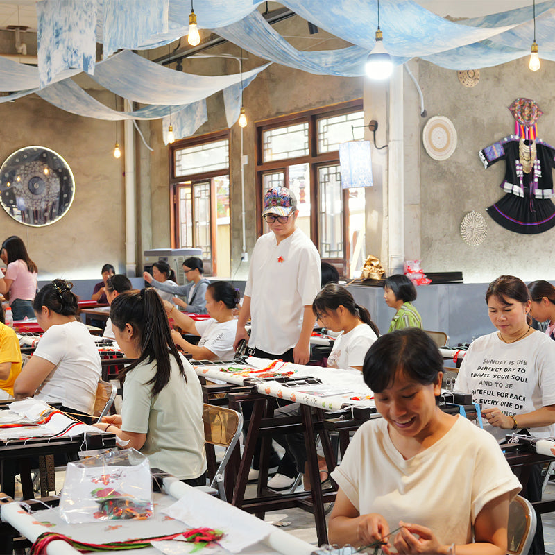 Artisans crafting custom embroidery in a workshop.