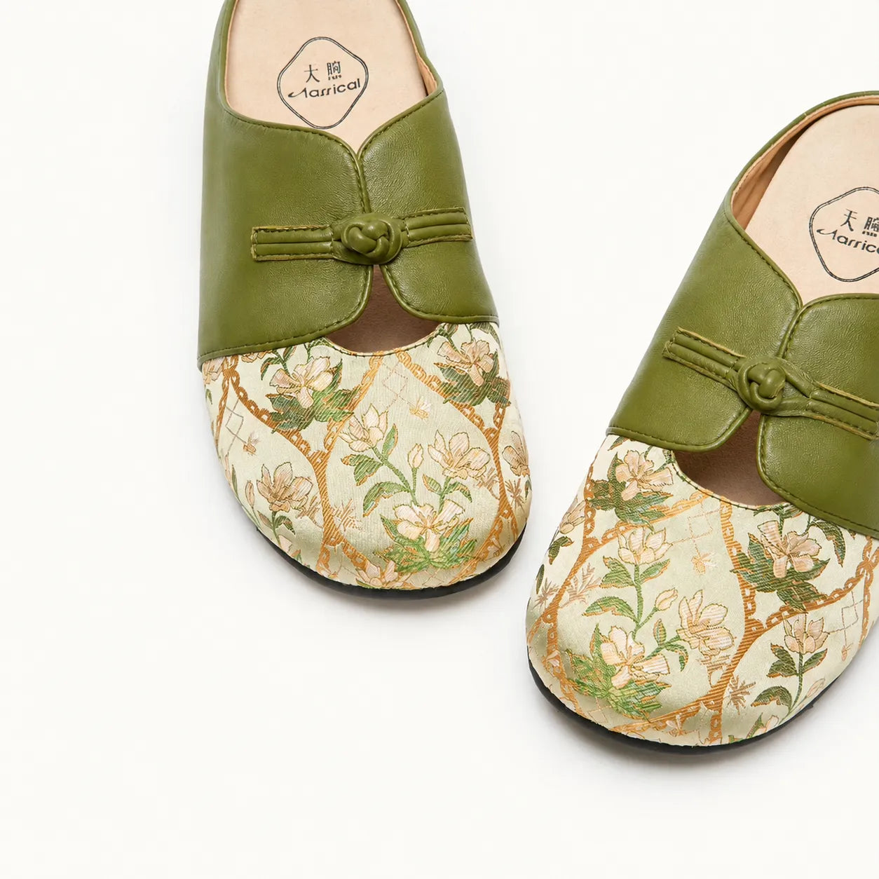 Close-up of Dayun Brocade floral mules featuring green leather and traditional floral textile details.