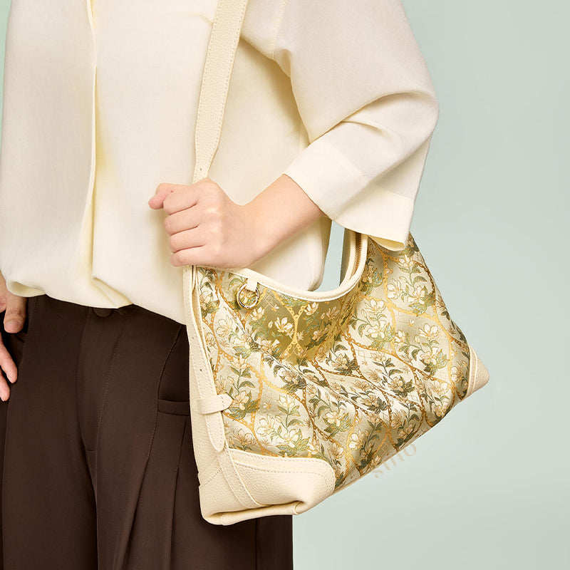 Model wearing the Dayun Brocade Verdant Floral Leather Crossbody Bag, showing the cream leather strap and elegant side styling.