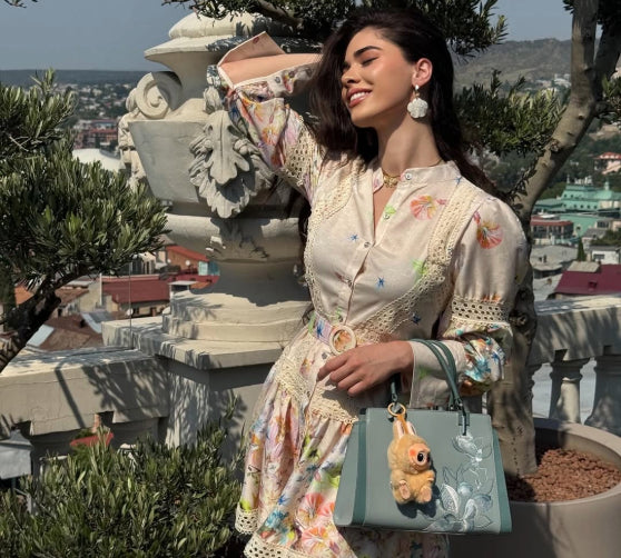 @elenne.kach wearing our Embroidery Magnolia Crossbody Tote Bag outdoors.