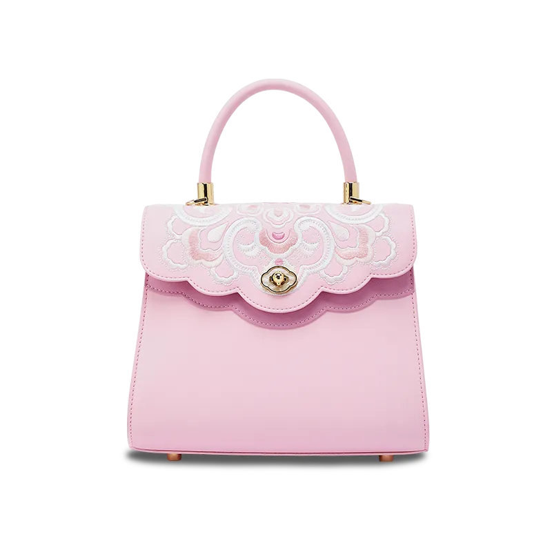 Embroidery leather ladies cute handbag in pink with treasure floral pattern, front view on white background.