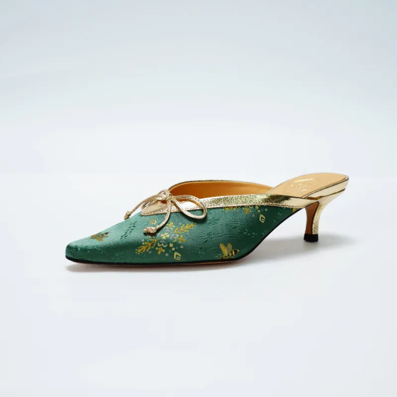 Side view of emerald green Shu Brocade mule heels with golden butterfly embroidery details.