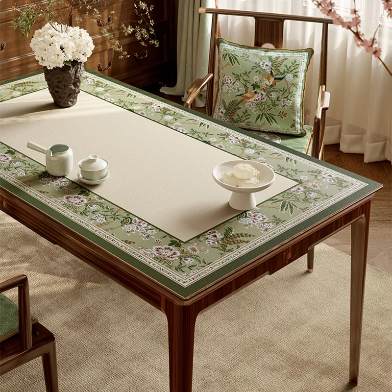 Emerald green floral leather table mat laid flat on table.