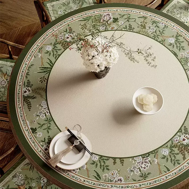 Emerald green floral table mat with bowls and vase on table.