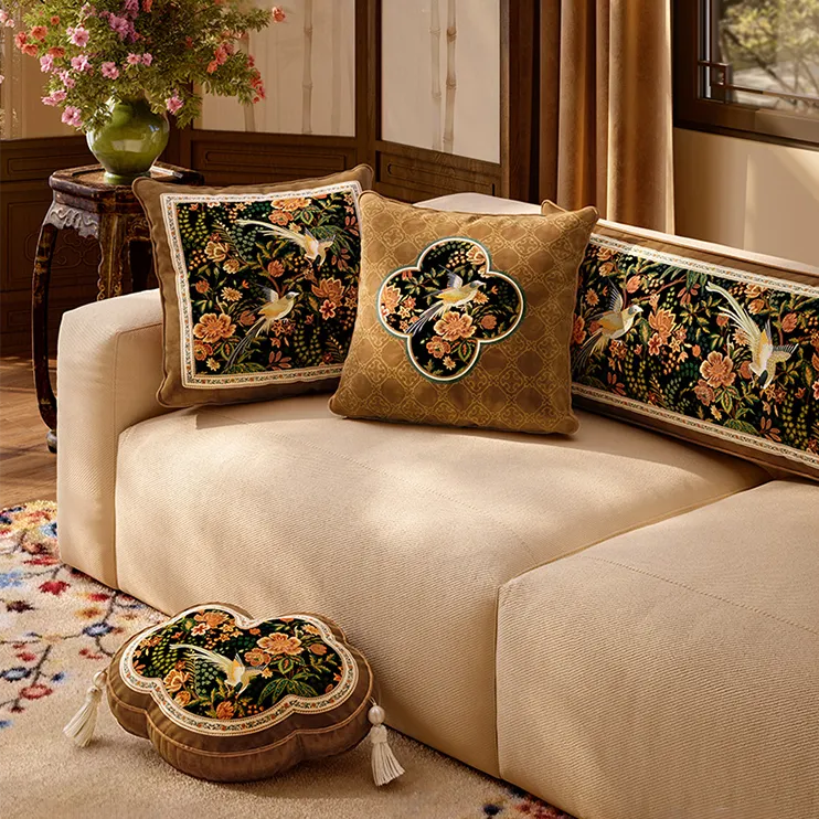 Beige sofa with Chinese floral-bird pillows for fall-winter home decor.