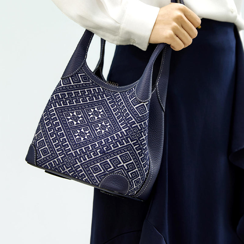 Flying Swallow Zhuang brocade basket tote bag worn on model shoulder, front view, highlighting structured basket shape and adjustable strap