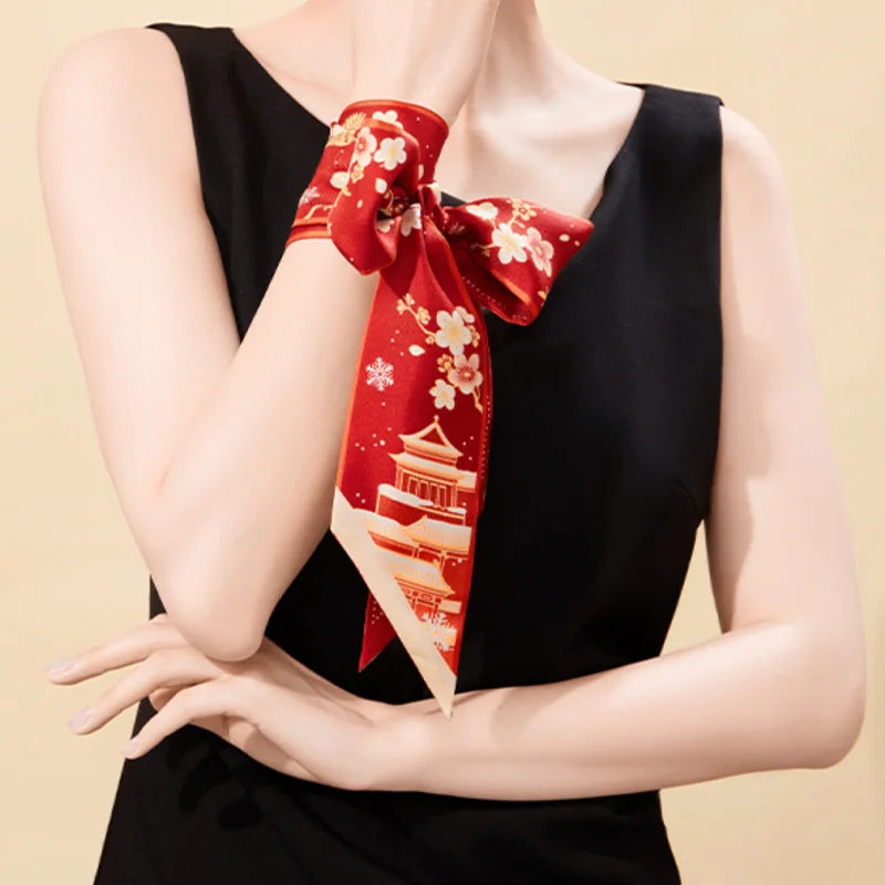 Woman styling the red Forbidden City Snowfall & Magpie Mulberry Silk Twilly as a bow wrist scarf.