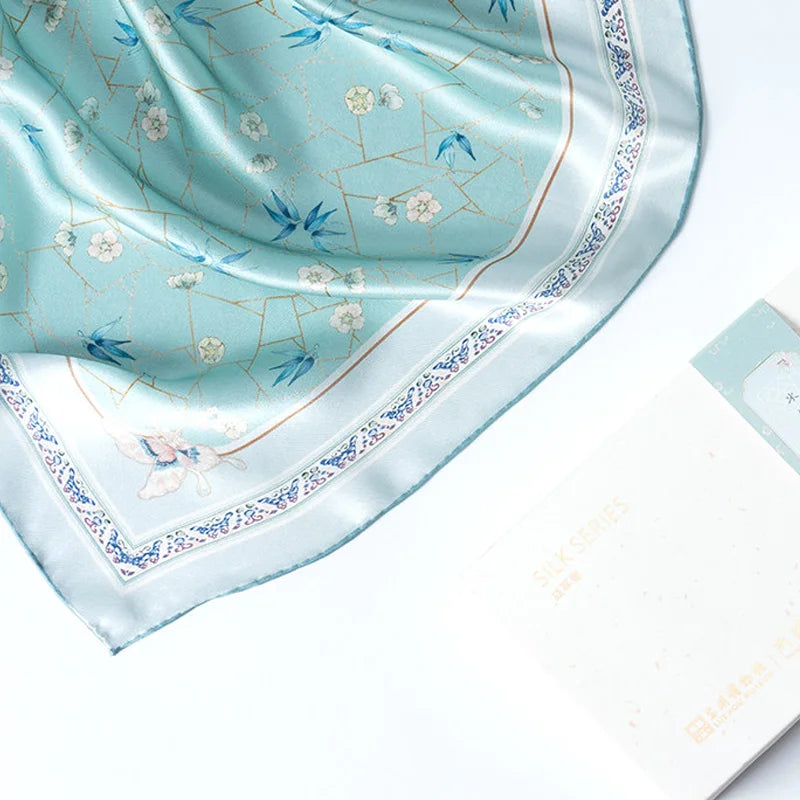 Ice-Crack Plum & Bamboo Mulberry Silk Square Scarf displayed with its blue-green floral print and decorative border.