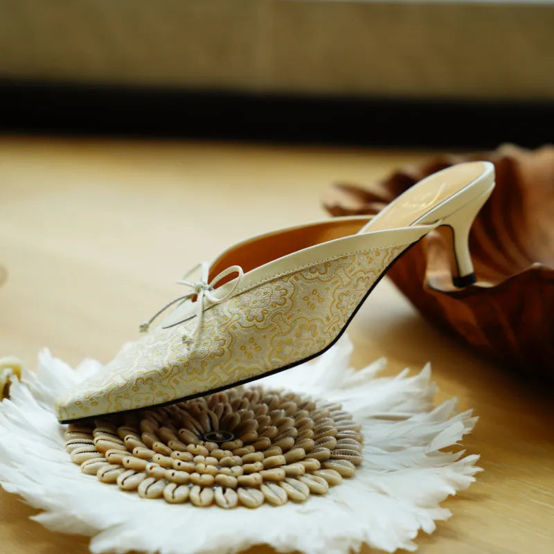 Ivory Chinese silk kitten heel mules with a pointed toe design, perfect for weddings and special occasions.