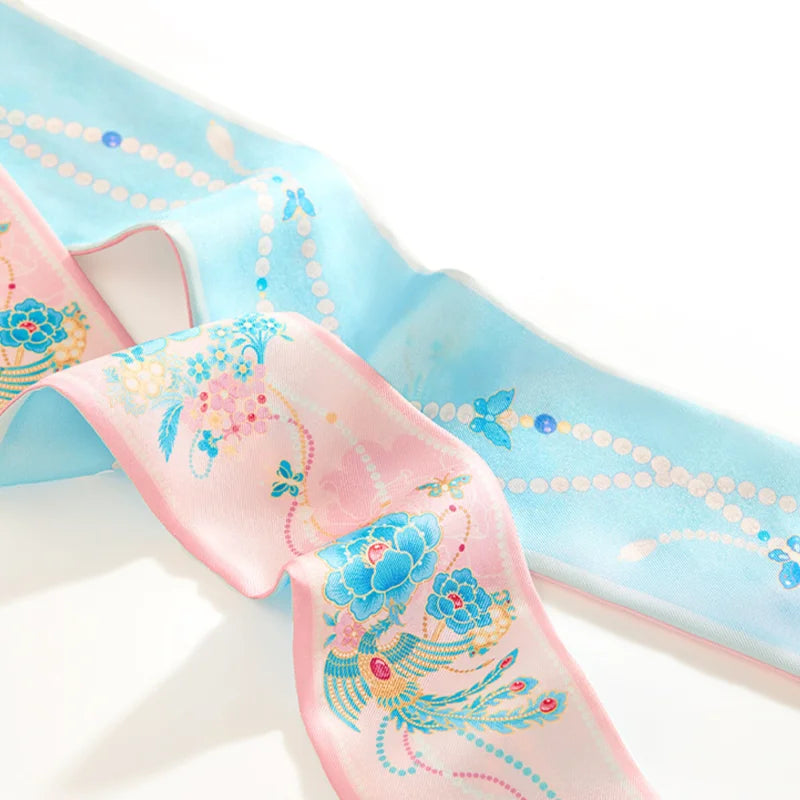 Close-up of the pink and blue Jeweled Phoenix & Peony Mulberry Silk Twilly with floral and jewel-inspired details.