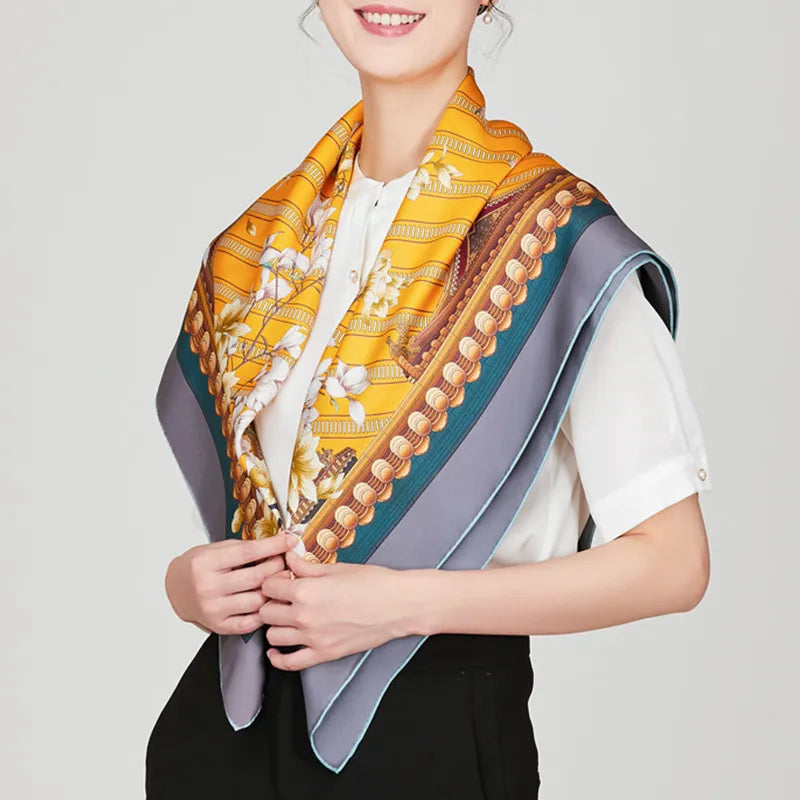 Model holding ends of mulberry silk scarf with floral design.