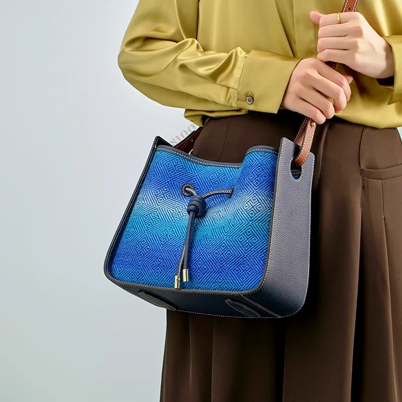 Model wearing the Luxury Chinoiserie Blue Starry Sky Zhuang Brocade Handbag crossbody at the waist, holding the strap with both hands.