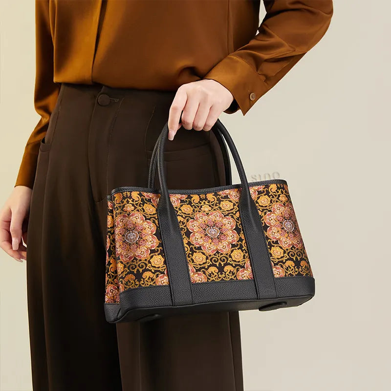 Side view of model carrying the Luxury Chinoiserie Dayun Brocade Pomegranate Motif Silk Handbag by one top handle.