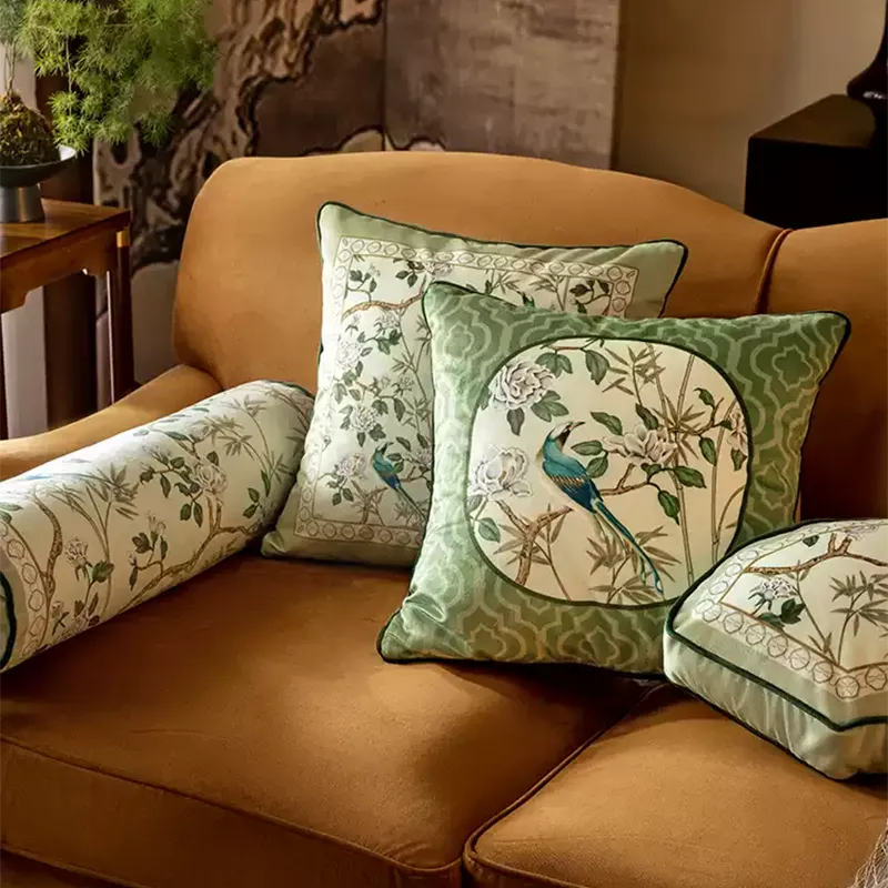 Luxury chinoiserie jade green throw pillows (A & B) styled on a living room sofa.