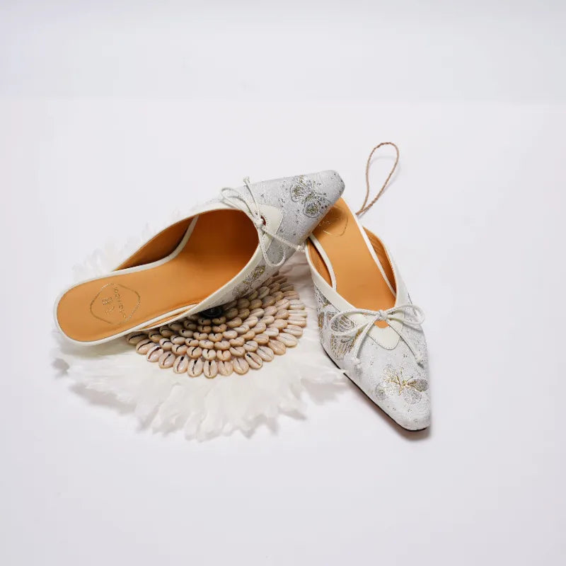 Flat lay of luxury Chinoiserie Song Brocade kitten heel mules showcasing butterfly-inspired textile artistry and elegant craftsmanship.