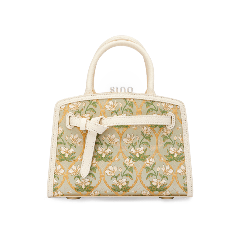 Front view of the Luxury Dayun Brocade Verdant Floral Large Leather Top Handle Bag with ivory leather trim and botanical brocade pattern.