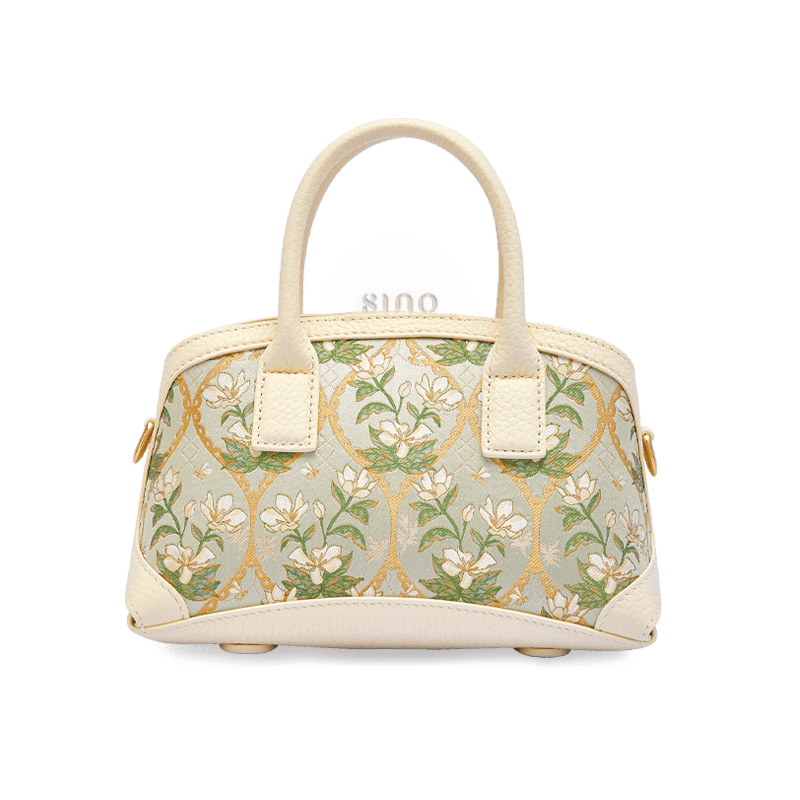 Front view of the Luxury Dayun Brocade Verdant Floral Leather Top Handle Bag with ivory leather and magnolia floral motifs.