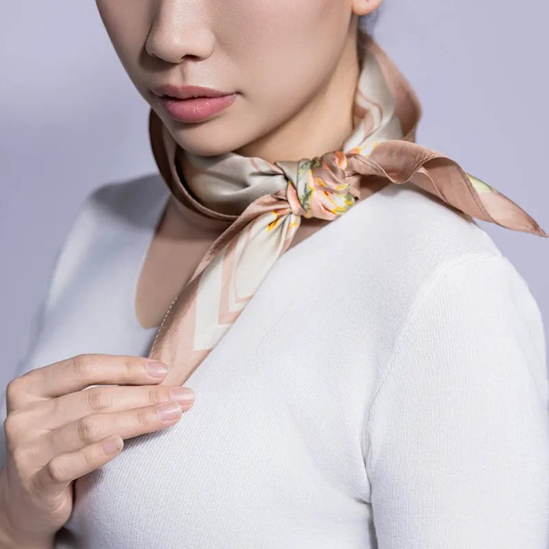 Cherry Blossom Birds mulberry silk square scarf tied at the side of the neck, showing an elegant styling option.
