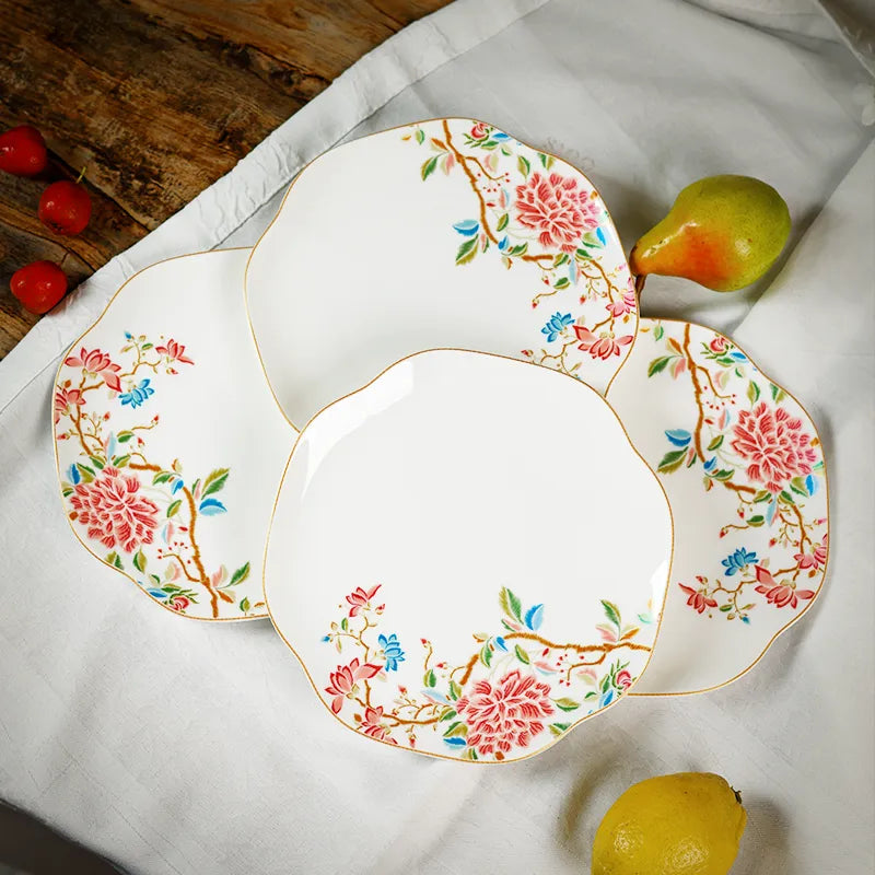 Floral bone china plates with pear decor on linen tablecloth, sophisticated dining.