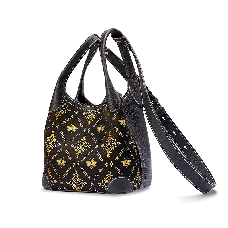 Angled view of the Luxury Shu Brocade Gilded Jade Leather Basket Tote Bag with long strap, showing the black leather side panel and gilded brocade design.