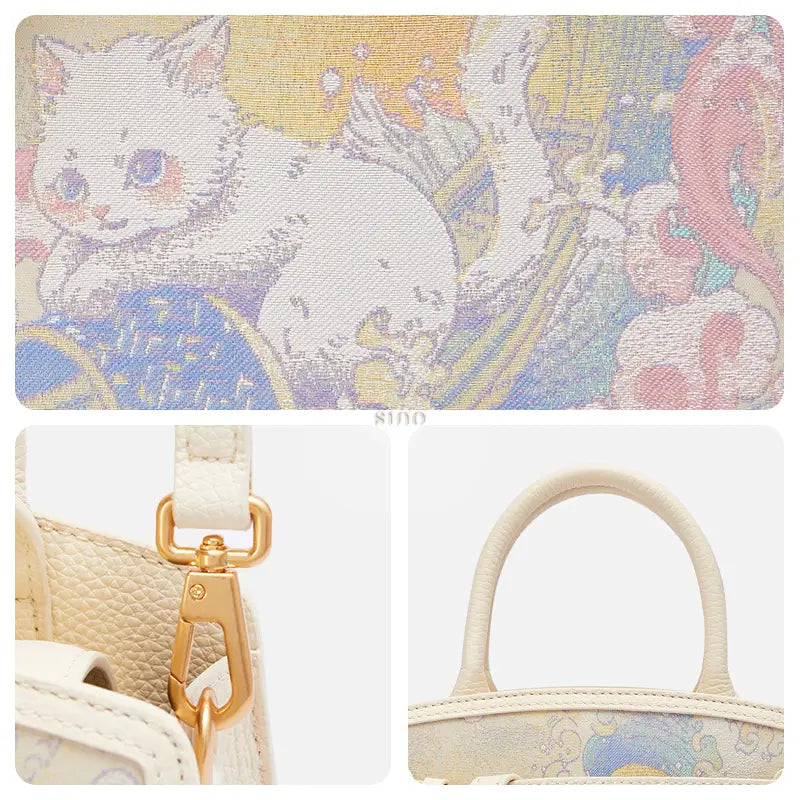 Detail view of the Brave Voyage Song Brocade cat motif, gold-tone hardware, and leather top handles on this luxury women’s handbag.