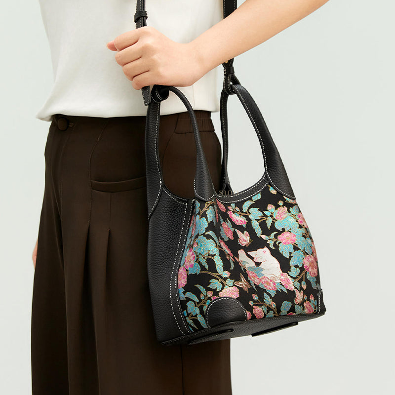 Model carrying the Luxury Song Brocade Butterfly and Auspicious Fox Basket Tote Bag, showing the floral fox motif, short handles, and adjustable shoulder strap.