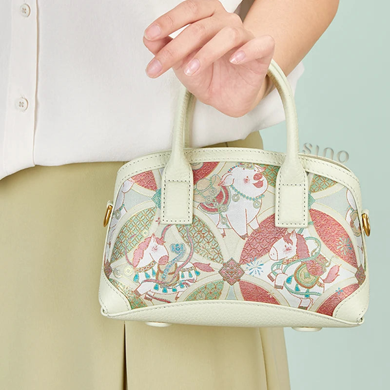 Close-up detail of the Luxury Song Brocade Enduring Prosperity Leather Top Handle Bag highlighting the brocade motif, gold-tone hardware, and leather handle.