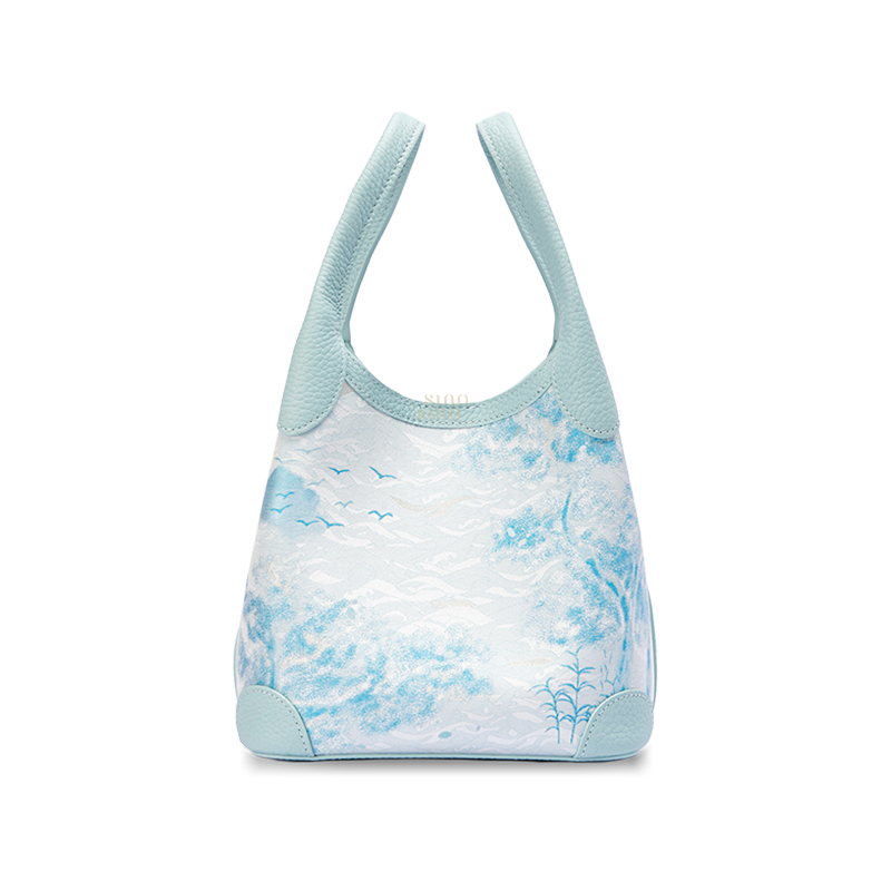 Front view of the Luxury Song Brocade Misty Mountain Forest Leather Basket Tote Bag, featuring a pale blue leather trim and a woven misty mountain landscape with forest and bird motifs.