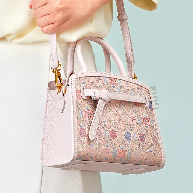 Model carrying the Luxury Song Brocade Ruyi Longevity Motif Leather Top Handle Bag with a detachable shoulder strap.