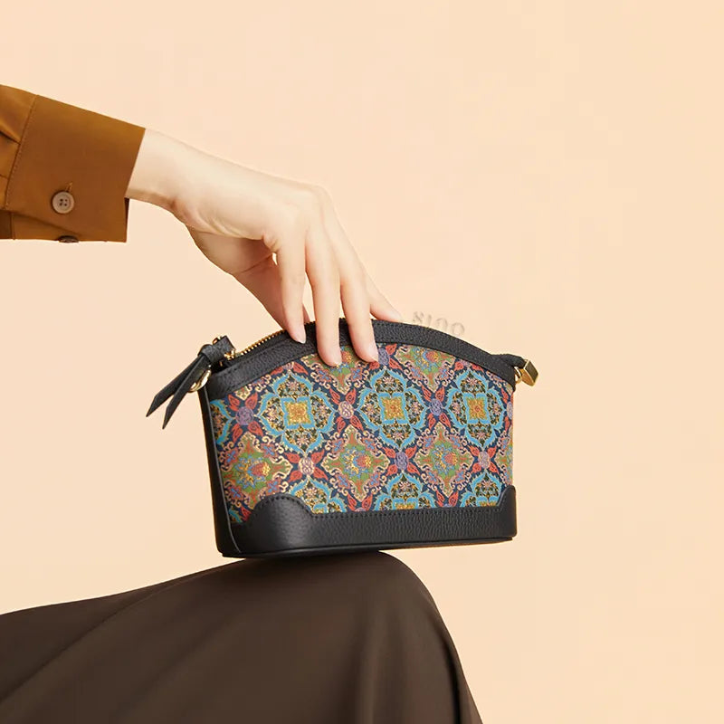 Seated model displaying the Luxury Song Brocade Scrolling Foliage & Lotus Motif Clutch Bag on the knees.