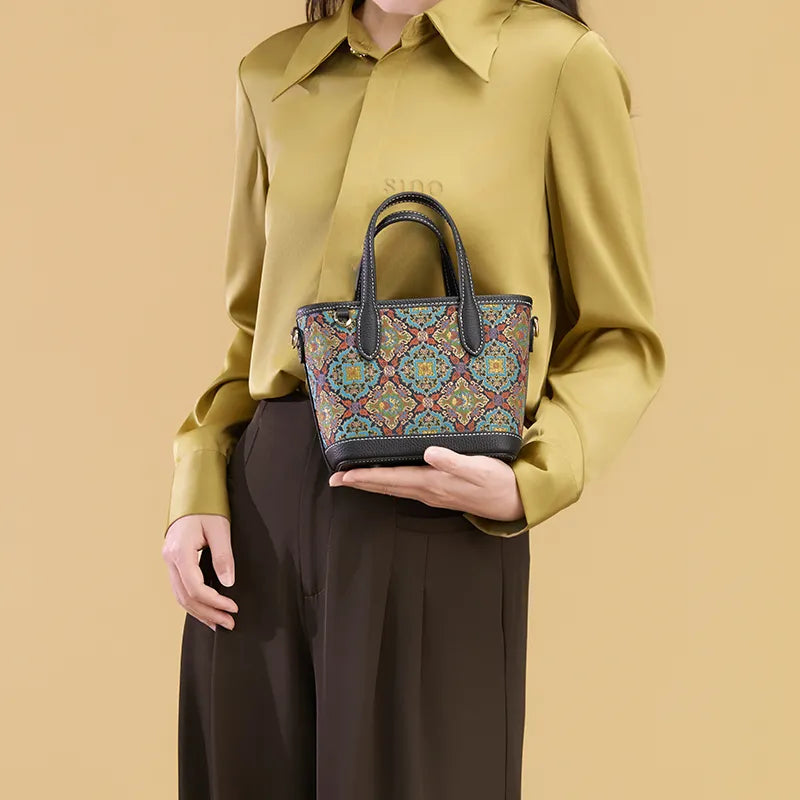 Model holding the Luxury Song Brocade Scrolling Foliage & Lotus Motif Handbag by hand in an elevated display pose.