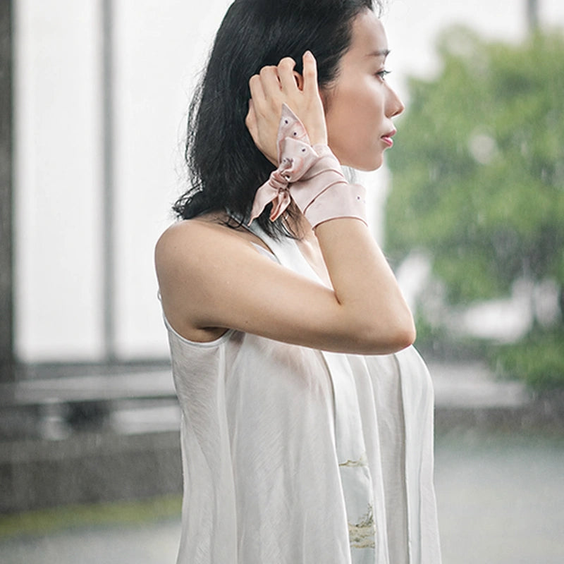 Woman styling the Chinese Misty Landscape Mulberry Silk Twilly with a minimalist white outfit.