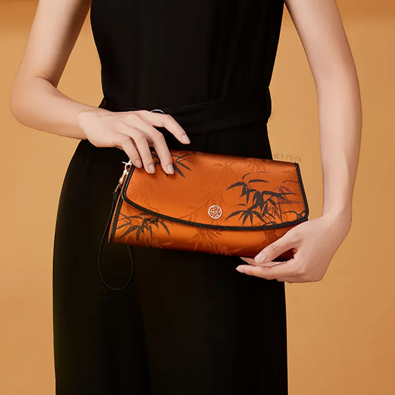 Model in Black Qipao Holding Vintage Brown Bamboo Silk Clutch.