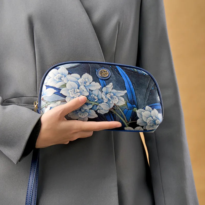 Model Holding Chinoiserie Blue Orchid Clutch to Chest.