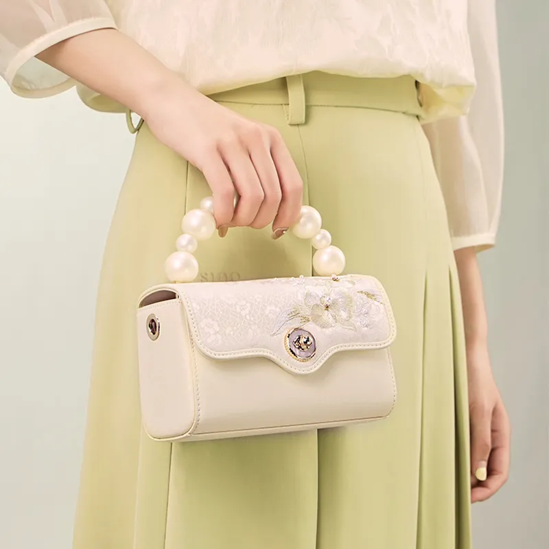 Model holding Luxury Orchid Butterfly Design Embroidered Silk  Handbag at front.