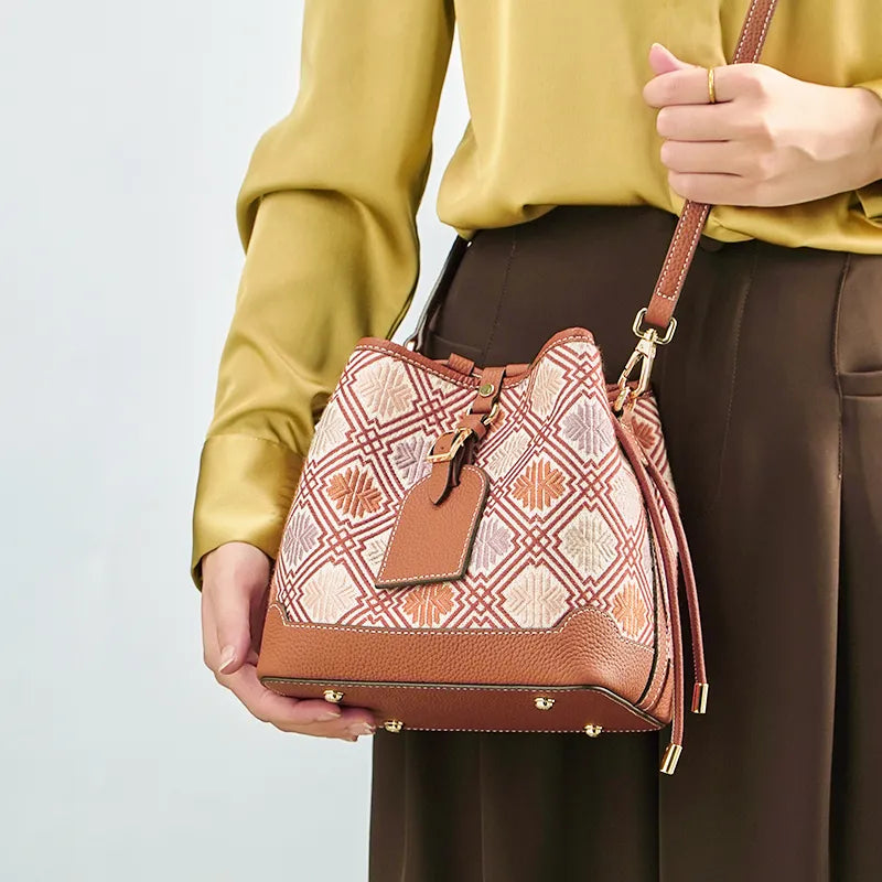 Model carrying chrysanthemum bucket bag crossbody style.