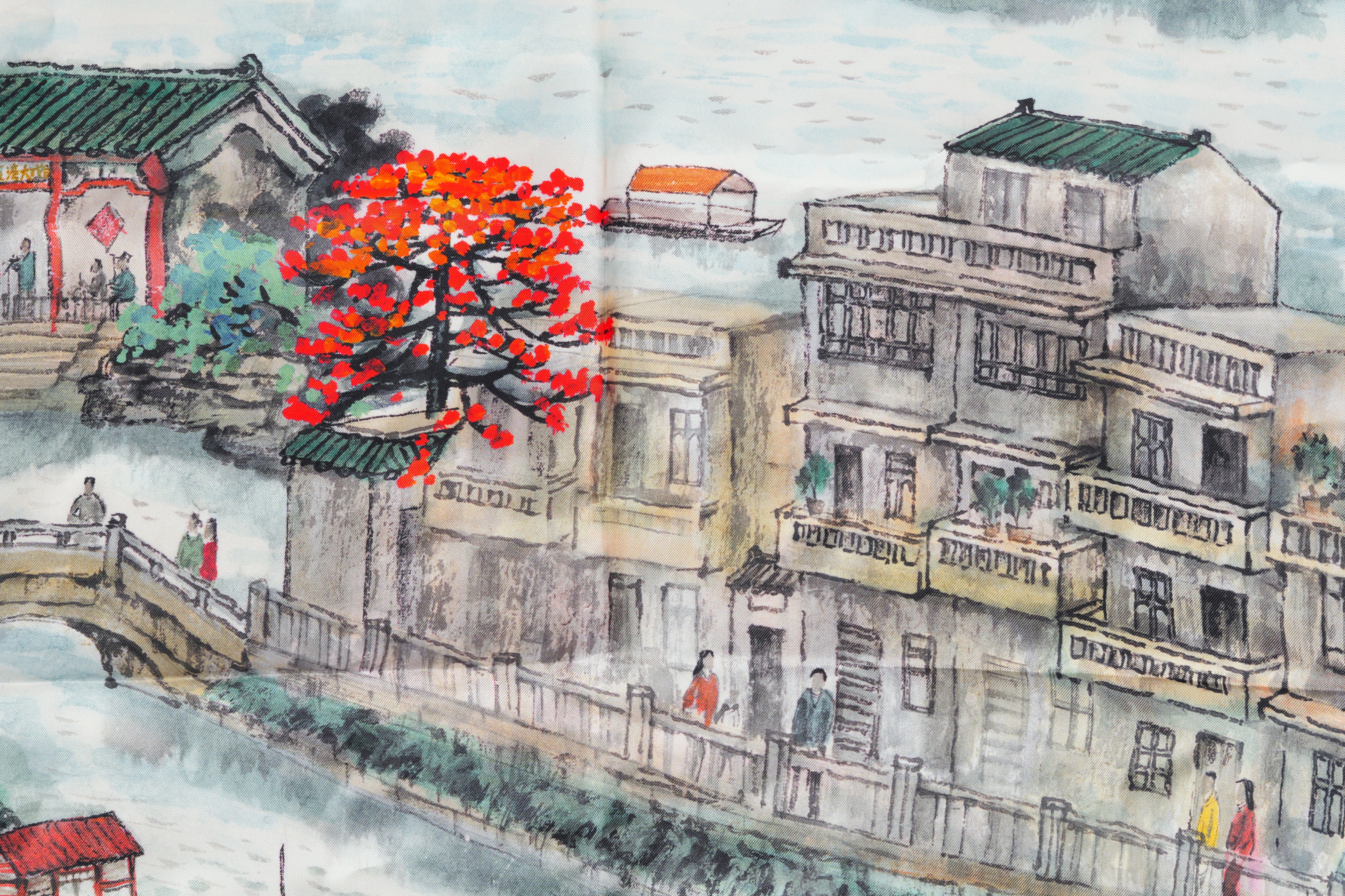 Luxury scarf border detail: hand-rolled hem and Cantonese floral lattice motif in gold thread, showcasing artisan craftsmanship.