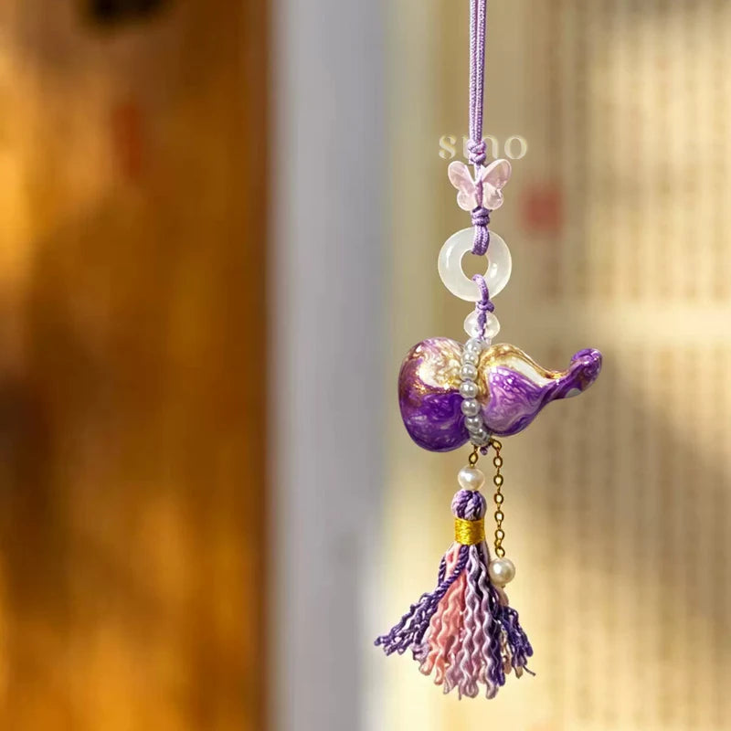 Auspicious purple Daqi lacquer Hulu tassel bag charm displayed hanging with gold-toned patterns, pearl details, a jade-like ring, and hand-knotted tassels.