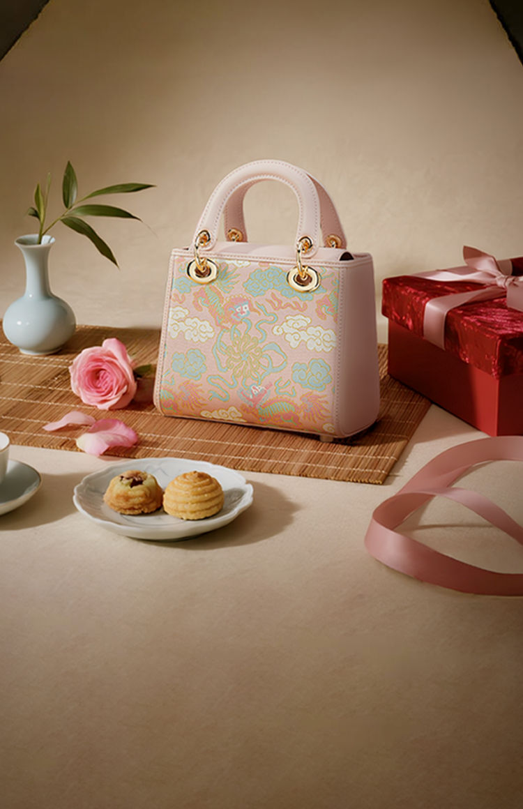 Qixi Festival banner: Pink traditional handbag with dragon/cloud patterns, red gift box, teacup, and romantic Chinese decor.