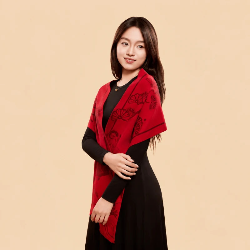 Red Year of the Goat scarf worn long over a black dress, highlighting its traditional sheep motifs and rich red color.