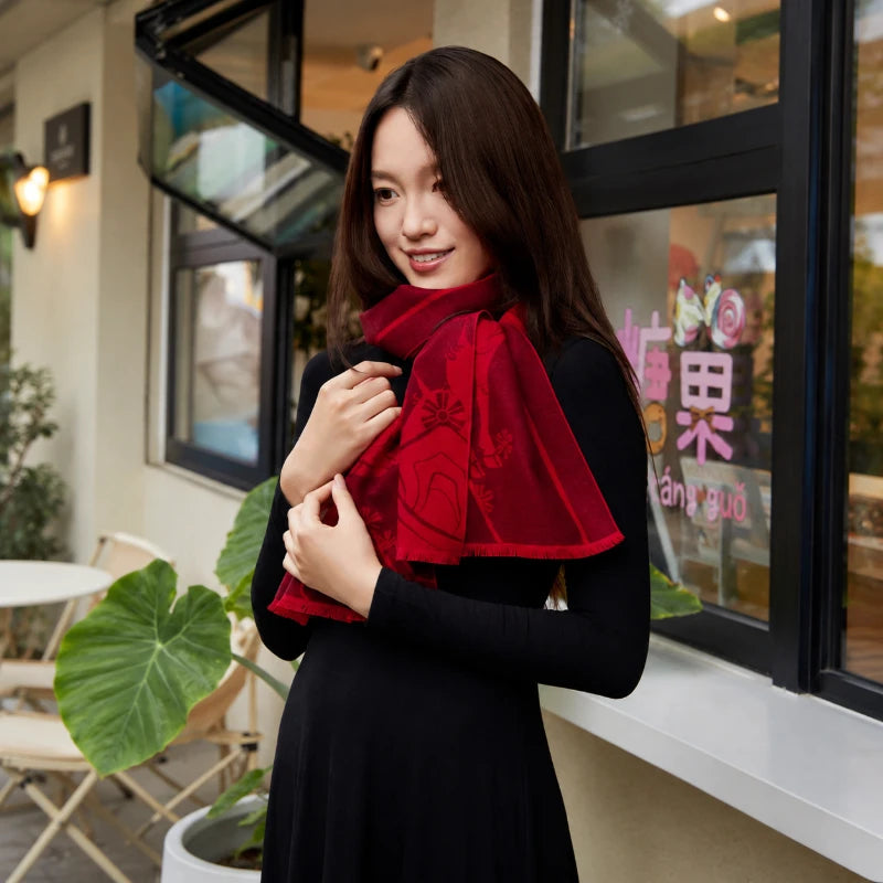 Woman wearing a red mulberry silk scarf as a shoulder shawl, showcasing its elegant drape and decorative patterns.