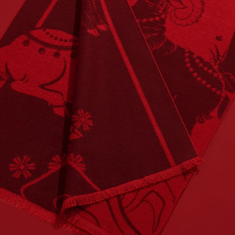 Close-up of the red silk scarf showing its traditional sheep motif, woven-looking pattern, and fringed edge.