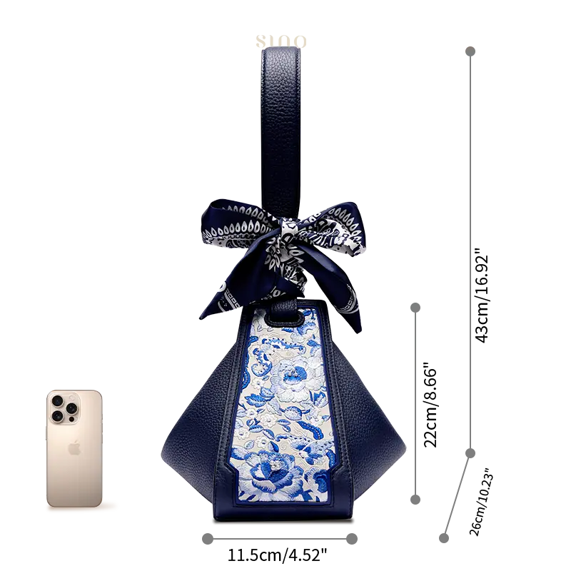 Size comparison of the SANLAN embroidered blue floral panel blue leather handbag beside a smartphone.