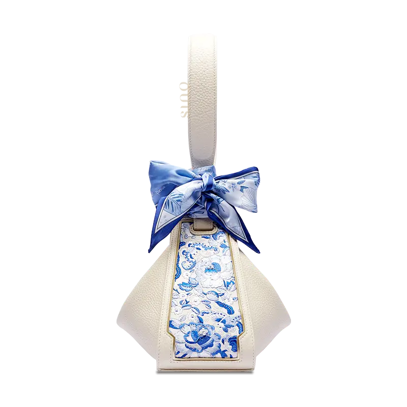 Beige leather handbag transformed into a Zongzi shape with a blue SANLAN embroidered floral panel.