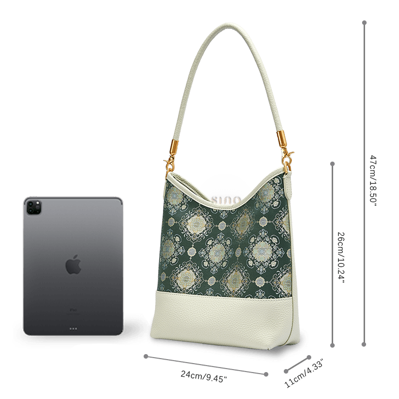 Size and capacity comparison of the Emerald Blossom leather shoulder bag beside a tablet.