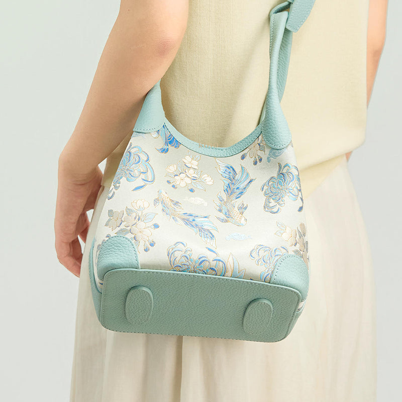 Back model view of the Luxury Shu Brocade Golden Fish & Flower Leather Basket Tote Bag, showing the light blue leather base, basket tote shape, and brocade body.